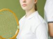 a woman in white shirt holding a wooden racket
