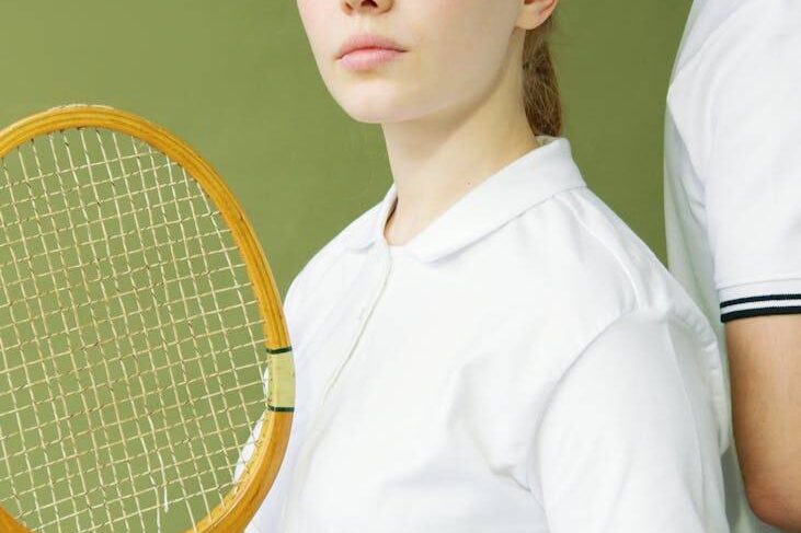 pexels-photo-7648364 a woman in white shirt holding a wooden racket