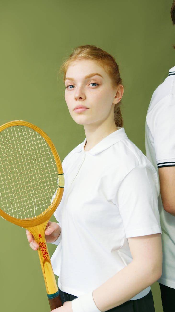 a woman in white shirt holding a wooden racket